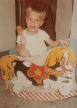 A young Michel Rainville riding a wooden horse