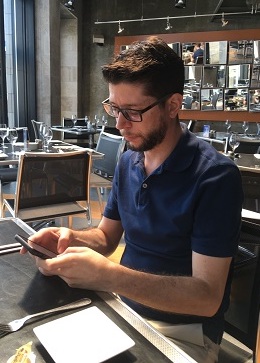 Philippe Papillon regardant son téléphone en attendant un repas au restaurant